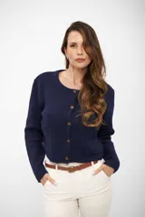 Saco de punto azul marino con cuello redondo, cierre frontal de botones y dos bolsillos delanteros tipo parche. Presenta mangas largas con puños acanalados y un diseño corto y estructurado.