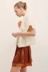 Short de satén de viscosa color verde militar, con apliques de encaje a tono en el ruedo y cierre invisible lateral.