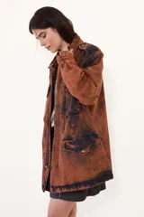 Parka de jean oversize con acabado lavado, cuello clásico, bolsillos frontales con tapa y cierre frontal. Presenta un diseño de silueta amplia y relajada con puños regulables.