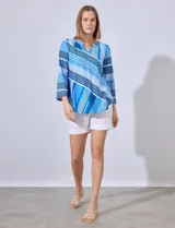 Blusa estampada a rayas azules y blancas, de la marca Ruby Rd. Tiene cuello a la base con escote en V y mangas tres cuartos regulables con presilla y botón.