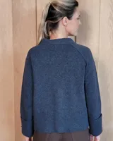 Cardigan de lana lambswool con diseño color block en tonos beige, marrón y turquesa. Presenta escote en V, cierre frontal con botones y puños anchos acanalados.