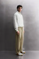 Pantalón jogger de corte relajado confeccionado en tejido compacto de algodón. Presenta cintura elástica con cordón interior, bolsillos frontales en la cadera y un bolsillo trasero de plastrón.
