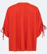 Blusa amplia color naranja, con escote en pico y mangas cortas con detalle de lazo fruncido.