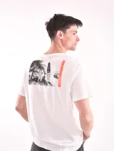 Remera verde claro de corte recto y mangas cortas, con estampado pequeño de palmeras y sol en el pecho.