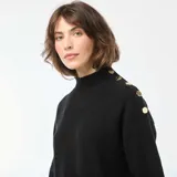 Vestido tipo sweater de punto color negro, con cuello alto y detalle de botones decorativos en el hombro. Presenta mangas largas con puños ajustados y un corte recto.