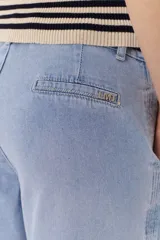 Pantalón jean negro de corte ancho y tiro alto, con pinzas delanteras y pespuntes laterales.