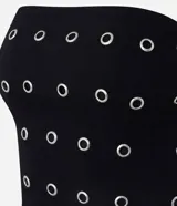 Blusa negra sin breteles, ajustada al cuerpo, con ojales metálicos distribuidos en la parte delantera y cierre de cremallera en la espalda. Confeccionada en bengalina con viscosa certificada.