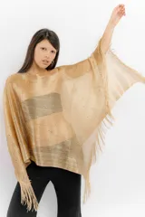 Poncho de tejido de punto metalizado en color dorado, con diseño amplio y flecos en el borde inferior. Presenta apliques sutiles de piedras y un estilo holgado.