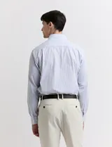 Camisa celeste y blanca a rayas verticales, de manga larga y corte clásico.