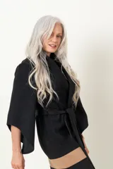 Chaquetón negro italiano con mangas irregulares, lazo y flecos en el ruedo.