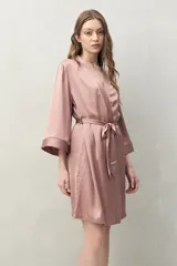 Bata de pijama negra de tejido satinado con leve elasticidad, silueta fluida y estilo envolvente. Presenta diseño cruzado con lazo regulable en la cintura y mangas amplias.