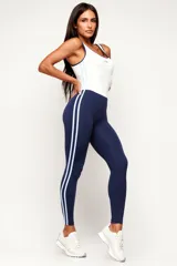 Monopieza deportiva color azul marino y blanco, con efecto bicolor que simula la combinación de una musculosa y calzas. Presenta dos tiras laterales en celeste y breteles medios.