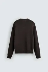 Jersey de corte relajado confeccionado en tejido de algodón. Presenta cuello redondo, manga larga y acabados en rib en puños, cuello y bajo.