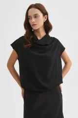 Blusa de poliéster color marfil, de corte holgado, sin mangas y con cuello buche drapeado.