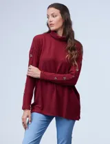 Polera negra de tejido soft con cuello alto y mangas largas con aplique de botones.