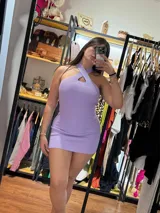 Vestido corto de hilo color lila, con escote halter cruzado y corte ajustado.