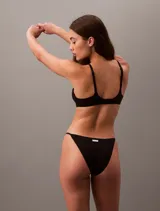 Sujetador negro sin aro, con copas de espuma elástica y tirantes finos ajustables que se pueden cruzar en la espalda.