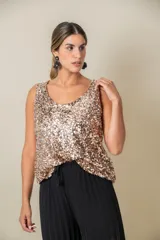 Blusa sin mangas confeccionada en tela cubierta de lentejuelas doradas y plateadas, con escote redondo y corte holgado.