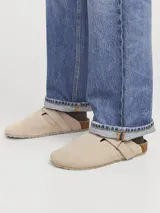 Zueco tipo mule de gamuza color taupe, con puntera redonda, tira ajustable con velcro y suela de corcho con base de goma.