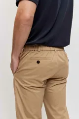 Pantalón chino de hombre en color marrón, corte recto y clásico, con bolsillos laterales y traseros.