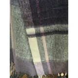 Bufanda rectangular de tejido grueso con diseño de cuadros en tonos gris, violeta y crema, terminada con flecos en los extremos.