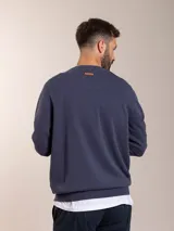 Sweater azul de tejido de punto con cuello redondo y logo bordado en el pecho.