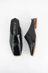 Zueco de cuero con textura tipo croco en color negro, con punta almendrada y taco bajo de madera.