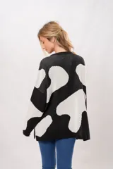 Buzo oversize de punto con estampado de manchas de vaca en blanco y negro.