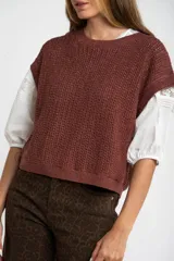 Chaleco sin mangas de tejido de punto color rosado pálido, con textura calada y acabado lurex, corte al cuerpo y cuello redondo.