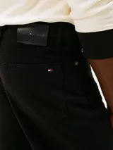 Jean de corte recto color negro, con diseño clásico de cinco bolsillos, cierre de cremallera con botón y detalles distintivos de la marca Tommy Hilfiger.