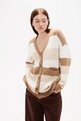 Saco de punto con diseño de rayas horizontales en negro, gris y blanco. Presenta cuello en V, cierre frontal con botones y bolsillos laterales.