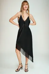 Vestido midi de satén negro con escote en pico, tirantes finos y bajo asimétrico con paneles de diferentes texturas.
