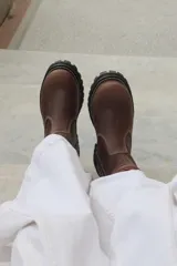 Botas cortas de cuero color marrón chocolate, con suela track negra y costuras a la vista.