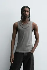 Camiseta sin mangas (tank top) negra, de corte slim fit, con cuello redondo de efecto doble.