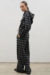 Pantalón de corte amplio y tiro medio-alto, confeccionado en tejido liviano con estampado a cuadros. Presenta cintura elastizada con lazo regulable y bolsillos laterales.