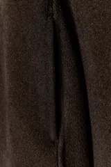 Chaqueta de corte recto confeccionada en hilatura con lana, en color marrón oscuro. Presenta cuello clásico en tejido efecto piel de ante, cierre frontal con cremallera metálica y manga larga.