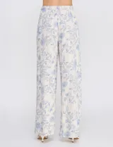 Pantalón palazzo de tiro alto con estampa floral azul sobre base beige, corte de pierna ancha, cintura elastizada con cordón de ajuste y bolsillos laterales.