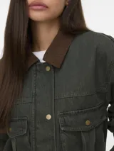 Campera de manga larga color verde militar, con cuello marrón contrastante, cierre frontal con cremallera y broches a presión. Cuenta con bolsillos delanteros con solapa y broches.