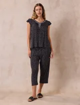 Conjunto de pijama marca René Rofé, compuesto por una remera de escote en V con botones y un pantalón capri con cintura elastizada, ambos en tejido soft estampado con motivos florales en tonos celeste y blanco.