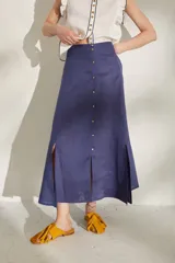 Pollera larga azul de tiro alto, con botonadura frontal y aberturas en el bajo.