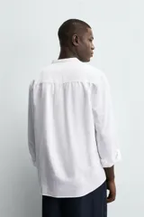 Camisa negra de lino y algodón, corte relaxed fit, cuello mao, manga larga con puños abotonados y cierre frontal con botones.