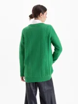 Sweater de punto color rojo con diseño de trenzas verticales y textura estructurada. Presenta cuello redondo, mangas largas y un corte holgado con terminaciones acanaladas.