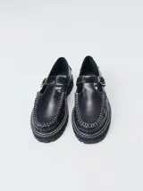 Zapato tipo guillermina de cuero color bordó, con diseño de mocasín, hebilla metálica y suela de goma con plataforma dentada.