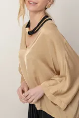 Blusa italiana de viscosa color beige, de calce holgado, con escote en V y detalle de lurex. Presenta mangas tres cuartos y diseño fluido.