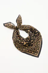 Pañuelo cuadrado estampado con diseño étnico o ikat en tonos negro y camel/marrón claro.