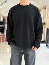 Buzo oversize marrón de manga larga, confeccionado en tela texturada con líneas verticales, cuello redondo y calce holgado.