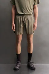 Short deportivo de entrenamiento color marrón, confeccionado en tejido técnico ligero y elástico. Cuenta con cintura elástica ajustable con cordón, bolsillos frontales, bolsillo trasero con cierre y aberturas laterales en el bajo. Incluye detalle de logo estampado en la pernera.