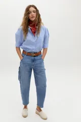 Pantalón de denim con corte barrel relajado y tiro medio, confeccionado en algodón con spandex. Presenta un estampado floral integral sobre fondo negro.
