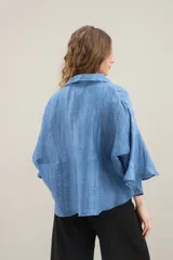 Camisa de silueta amplia y fluida color celeste, con cuello camisero clásico y mangas cortas amplias.