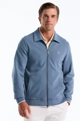 Campera de punto azul con cierre frontal completo, cuello tipo camisa y bolsillos ribeteados, decorada con el logo del pingüino bordado en el pecho.